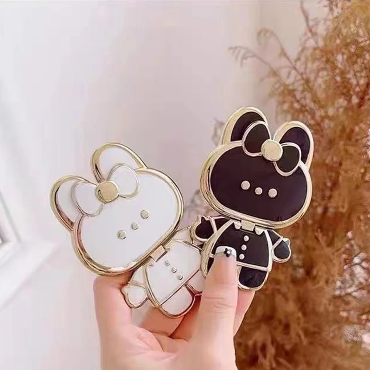 Un soporte para teléfono galvanizado reversible en forma de conejo con espejo y soporte para teléfono