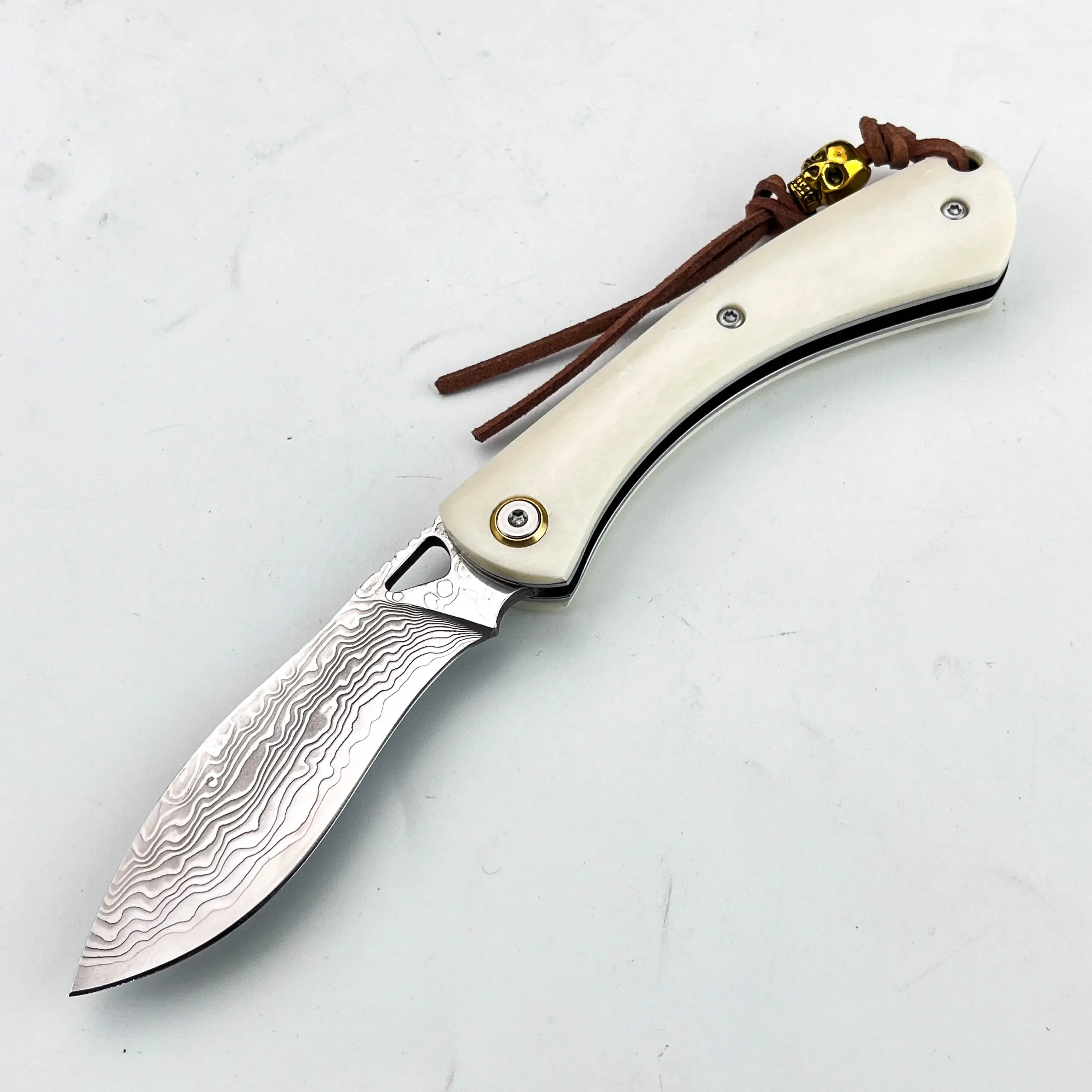 Damascus Folding Knife with Creamy Ivory Handle Leather Lanyard Golden Skull Ornament Perfect for Camping Outdoor EDC Carry