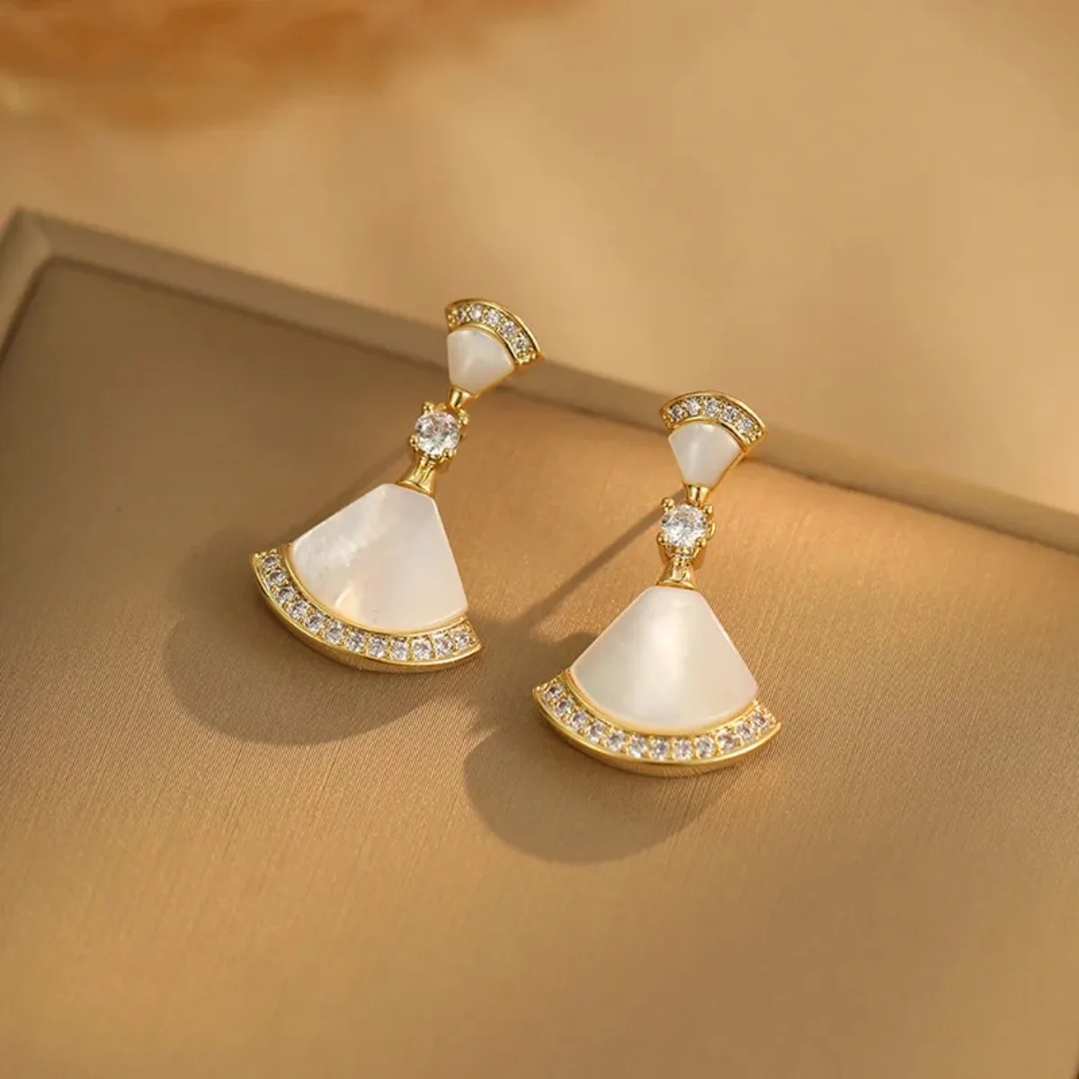 Un par de aretes con forma de abanico, de alta gama, modernos y sencillos, adecuados para que las chicas los usen en banquetes y bodas.