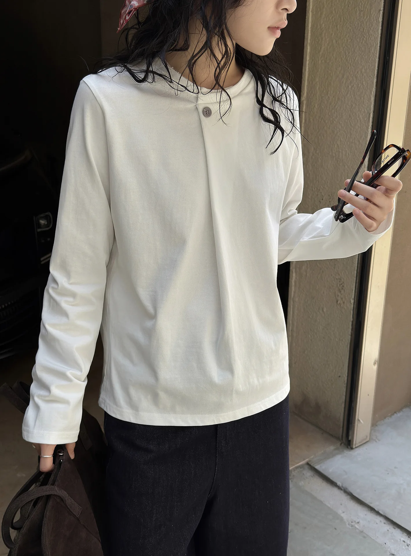 Nuovo senso del design francese di inizio autunno, T-shirt a maniche lunghe con abbottonatura obliqua a un bottone, top con silhouette ampia per le donne