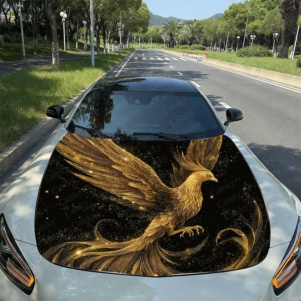 Elegant golden phoenix design on a car hood, featuring intricate details and sparkling stars against a black background. Perfect