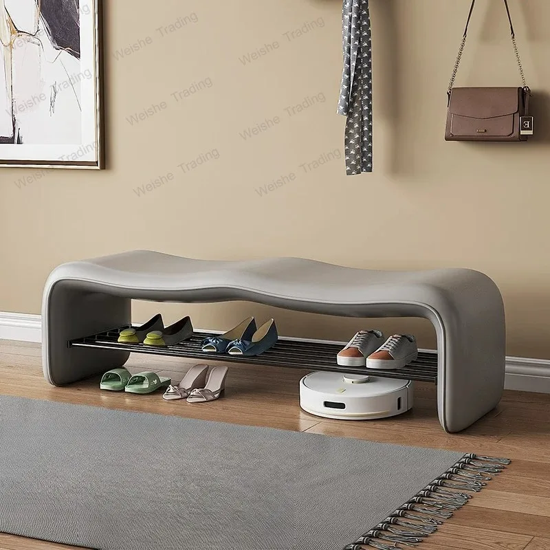 a bench at the end of the bed in the bedroom, and a shoe change stool door for household use.