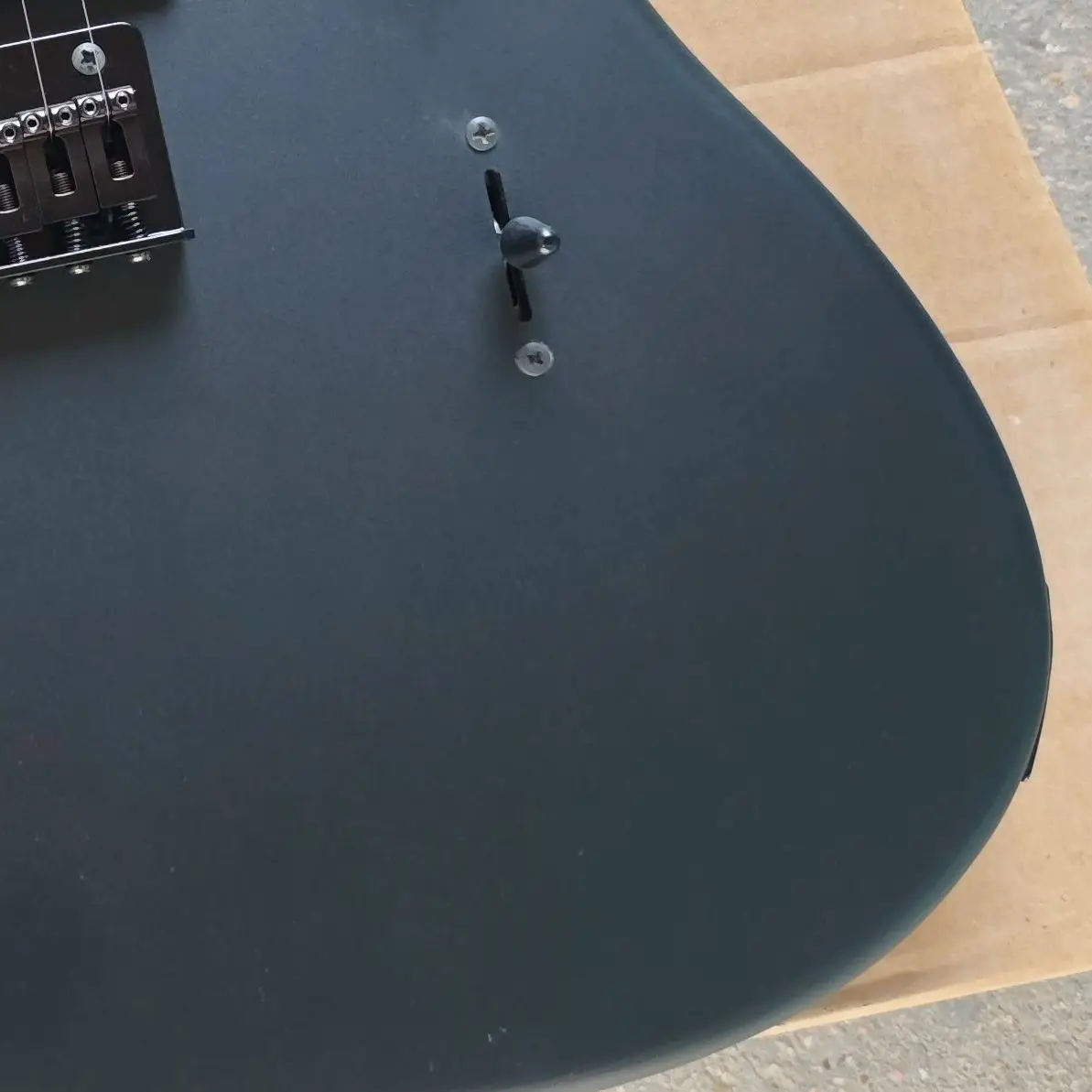 Black six-string electric guitar with matte paint, basswood body, maple neck and rose wood fingerboard.