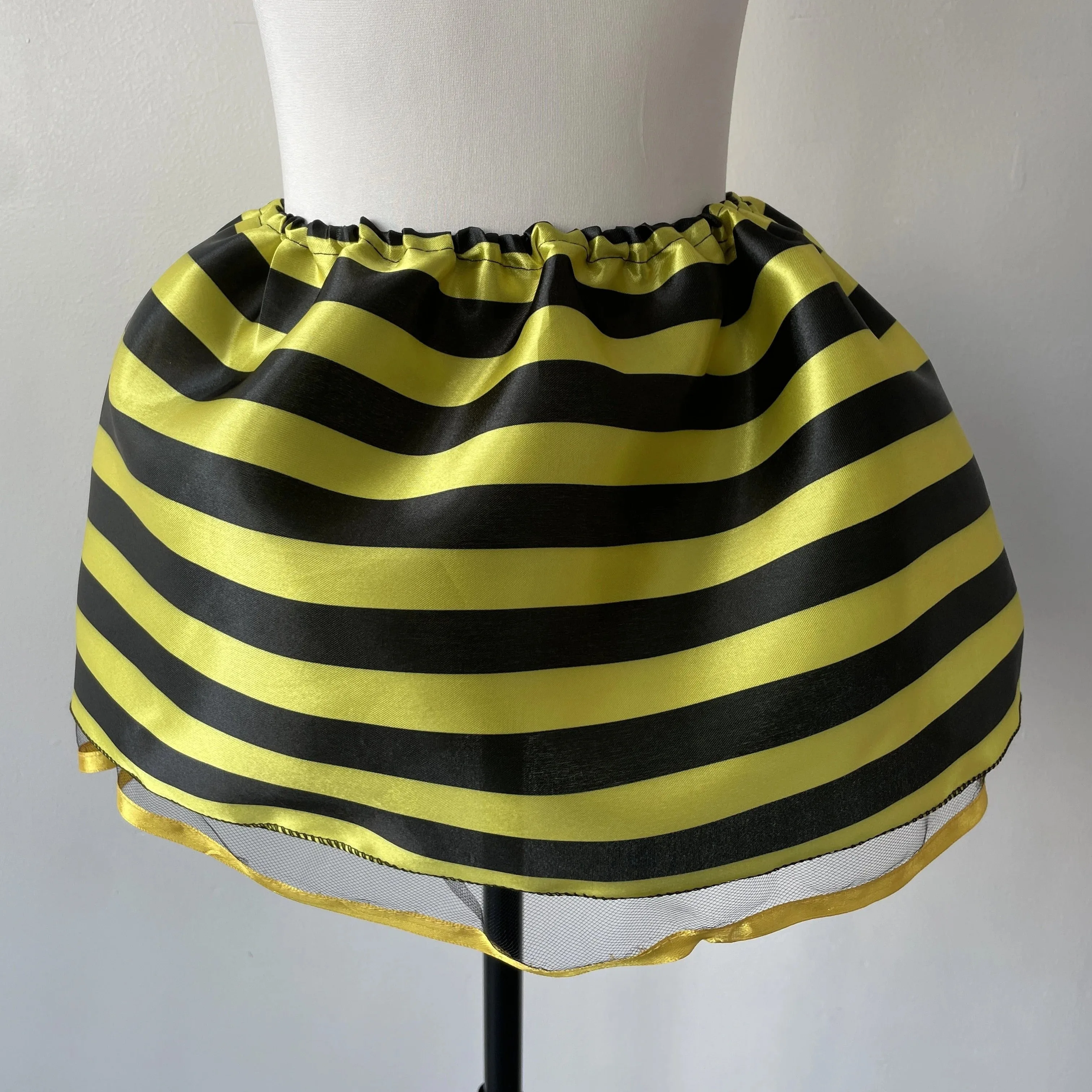 A Children's Bee Dress Skirt, With Yellow and Black Floral Fabric on the Outside and a Layer of Mesh on the Inside