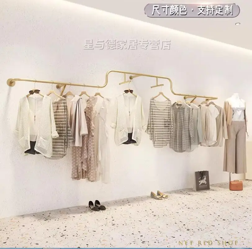 

Wall mounted shelves for women's clothing display on display shelves in clothing stores, with clothing hangers in gold color