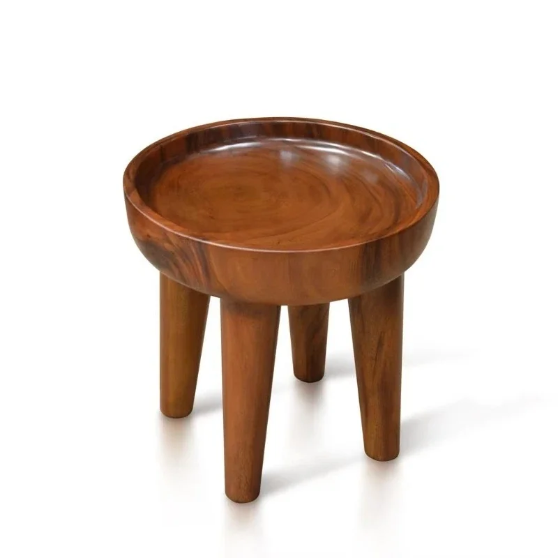 The unique concave of the modern round side table displays items safely handmade from a single piece of wood