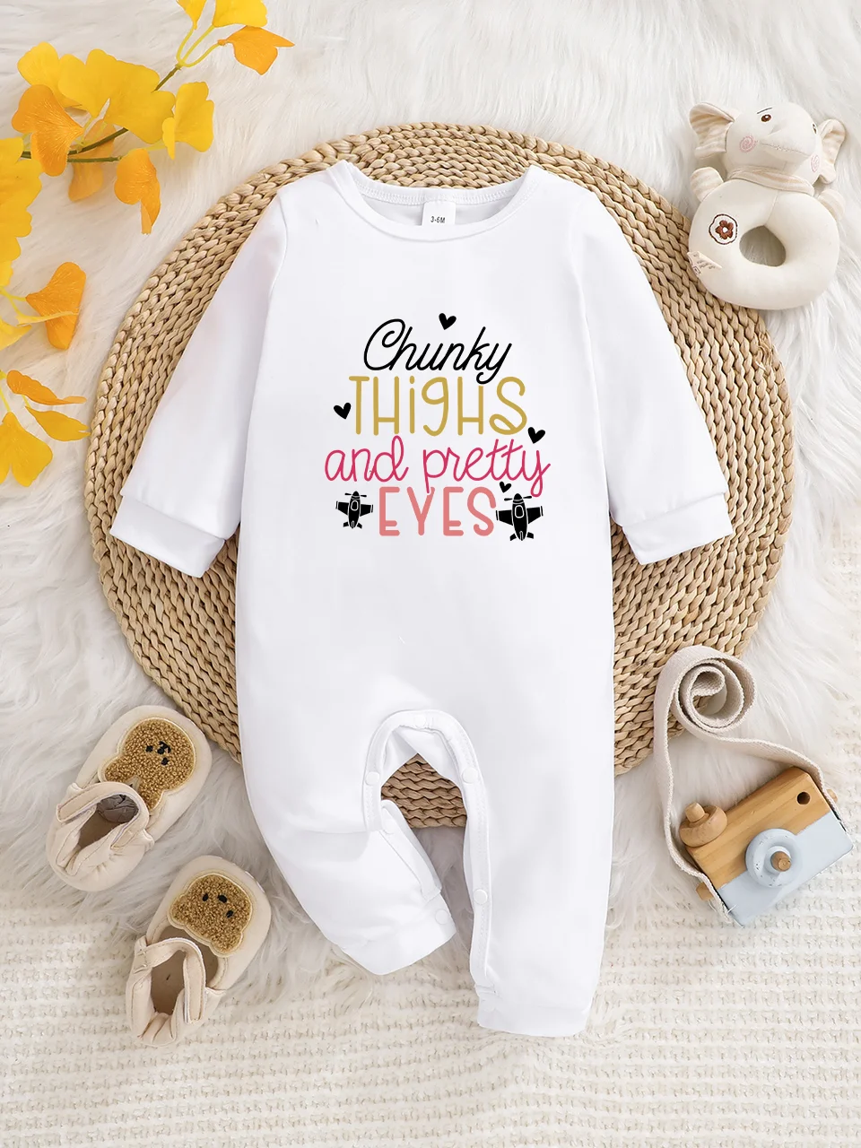 A baby long-sleeved onesie with interesting letter prints. It features a buttoned design for easy putting on and taking off, and