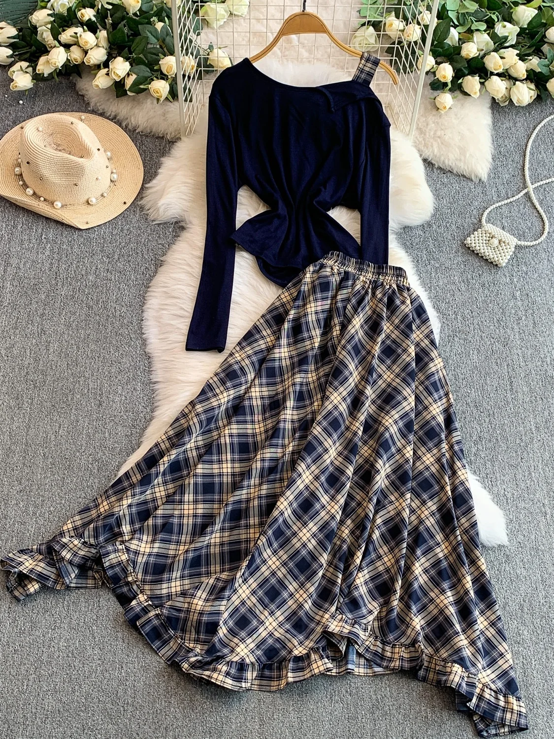 Conjunto de duas peças: Blusa e estilo irmã com babados e alça assimétrica e saia longa com estampa xadrez.