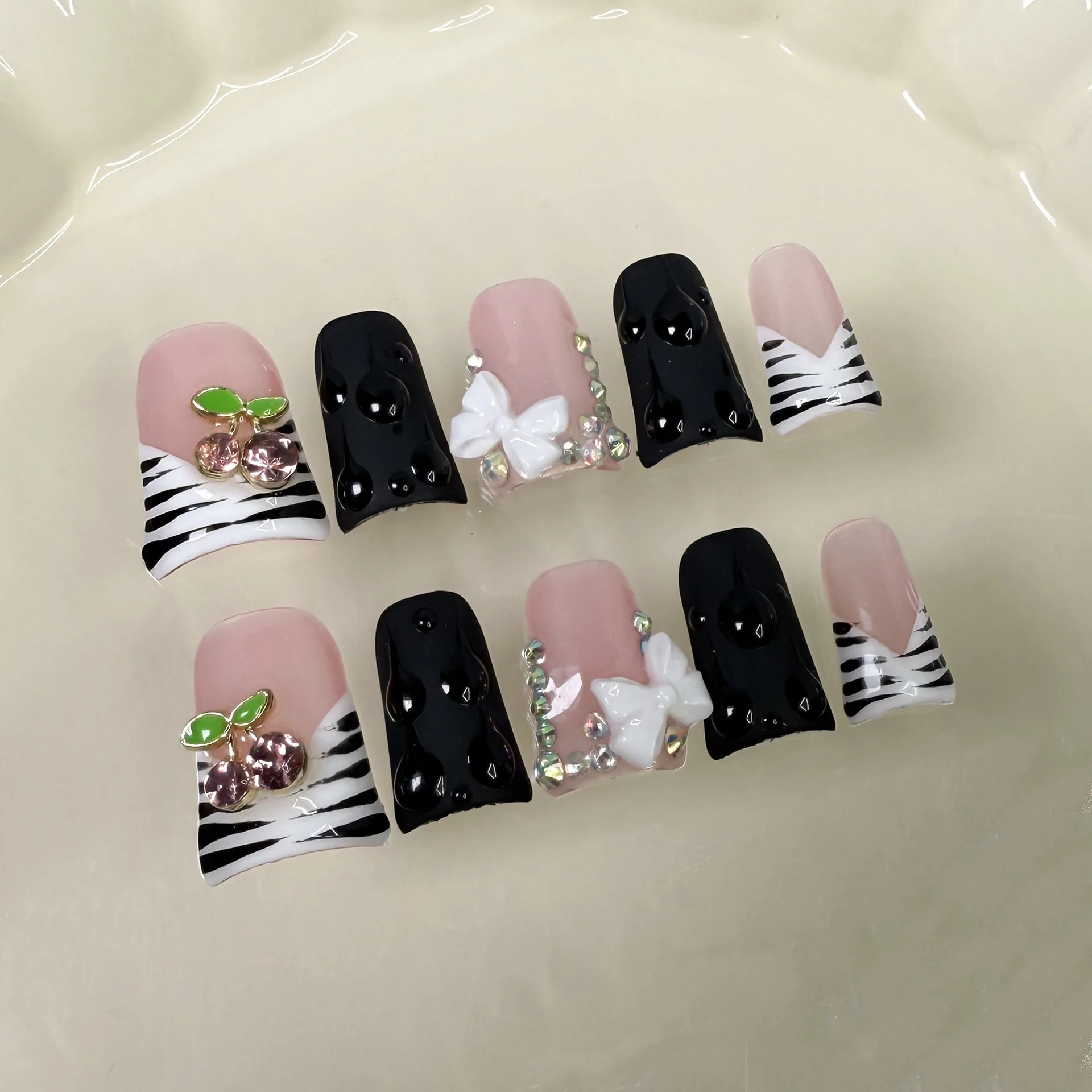 เล็บปลอมแบบกดติดลายม้าลายสไตล์ฝรั่งเศส 10 ชิ้น ประดับด้วยคริสตัลรูปเชอร์รี่และโบว์สีขาว ทำมือ เล็บปลอมสีดำแบบปากเป็ด