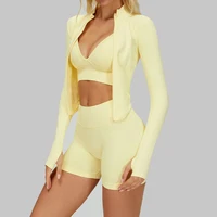 Women’s yellow sports bra, high-waisted gym shorts and cropped zip jacket set