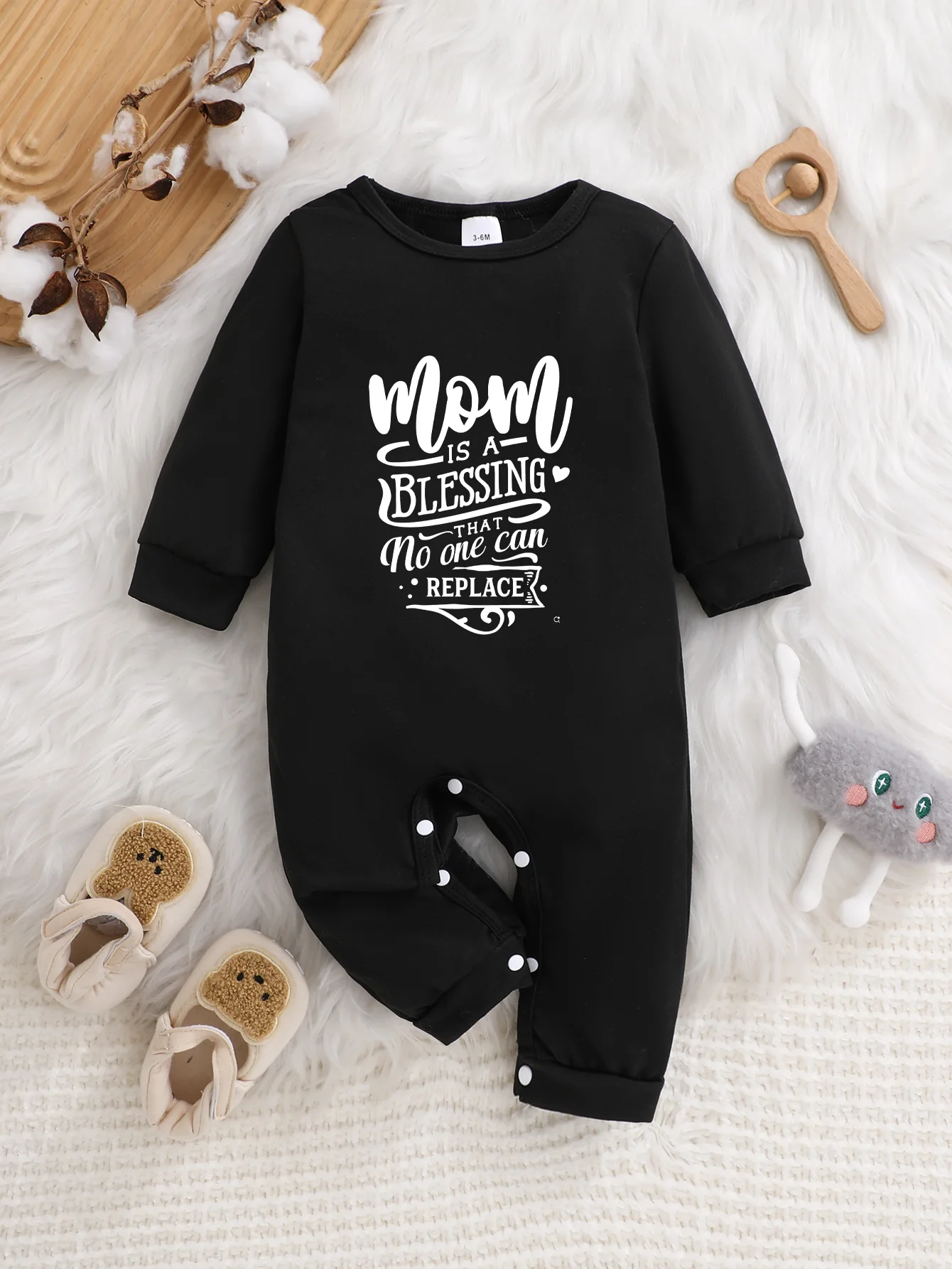 A baby long-sleeved onesie with interesting letter prints. It features a buttoned design for easy putting on and taking off