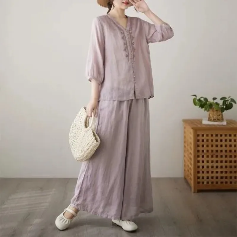 

Женский комплект из двух предметов: блузка с V-образным вырезом и рукавами до локтя из светло-фиолетового льна и широкие брюки свободного кроя, повседневный, удобный.