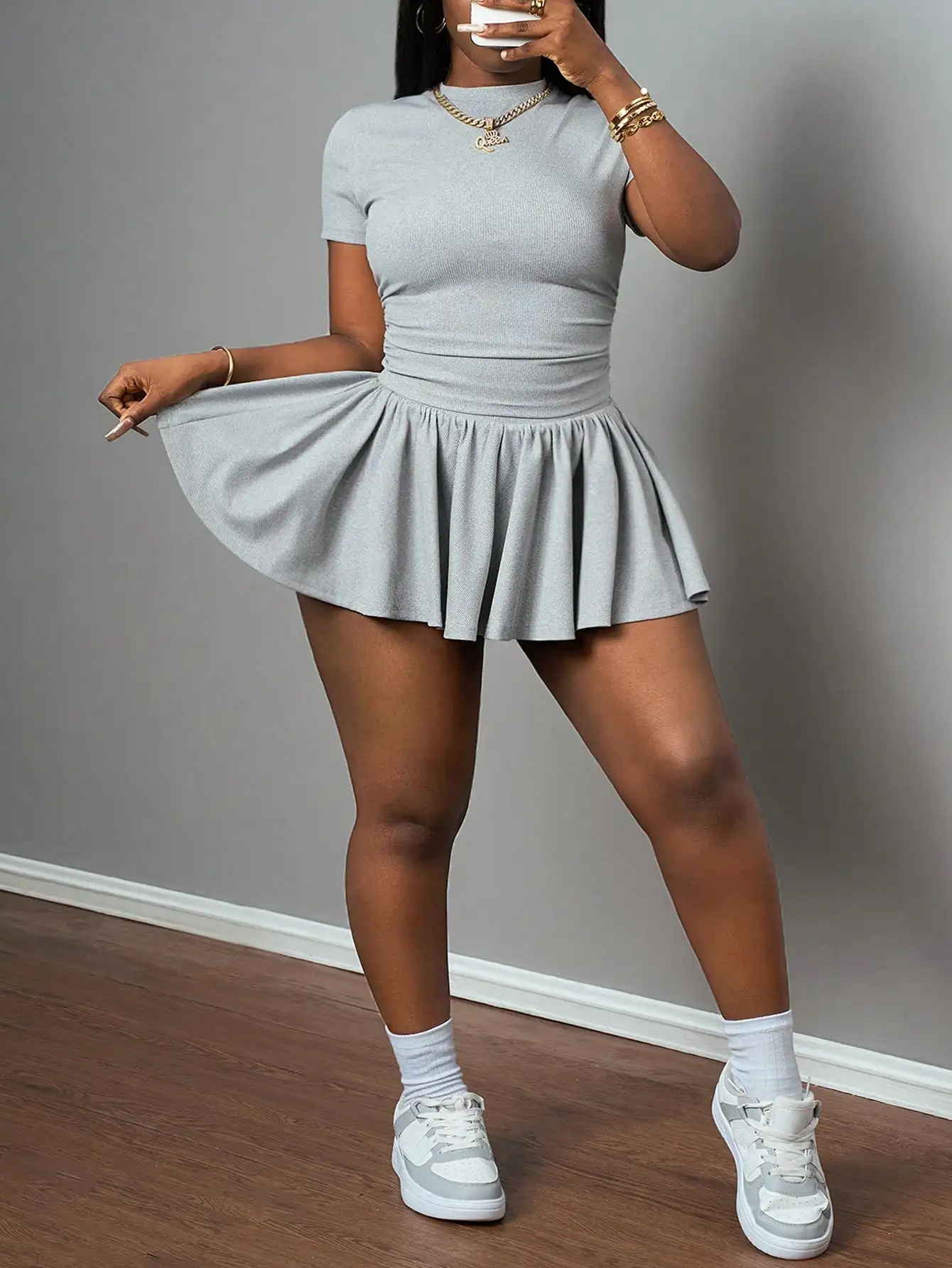 

Светло-серый трикотажный комплект из двух предметов: топ с коротким рукавом и плиссированная юбка, повседневный спортивный стиль