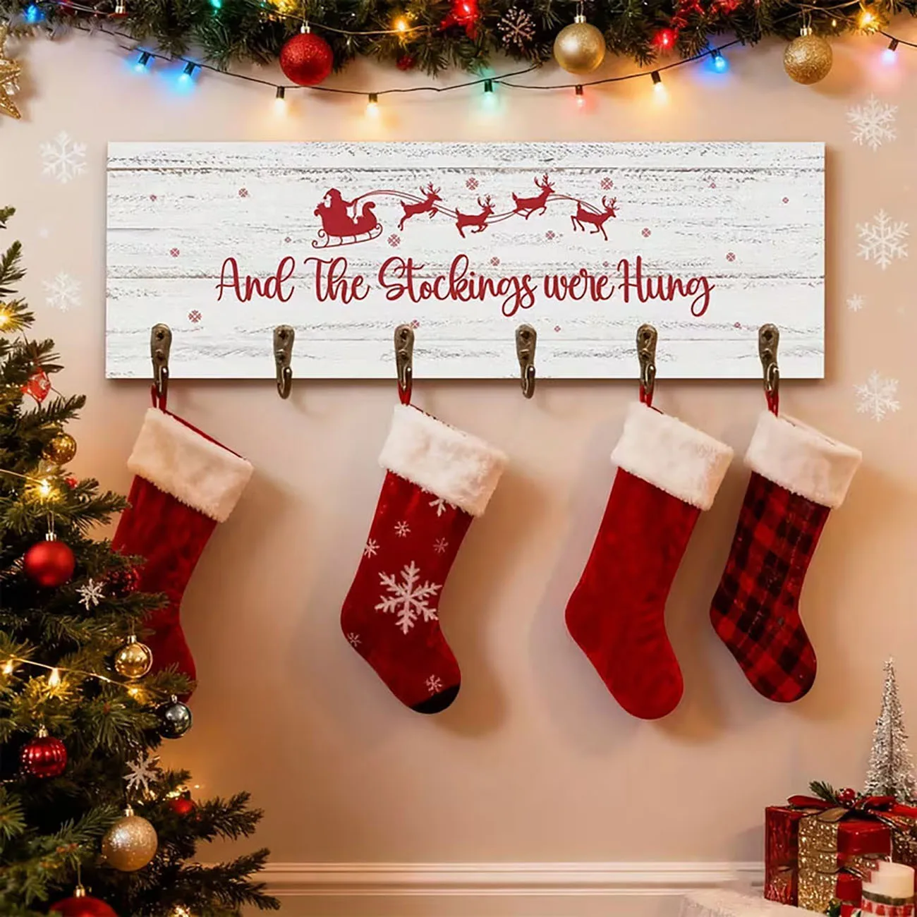 Distressed white wooden stocking holder printed with Santa’s sleigh, six metal hooks, rustic Christmas wall decor.