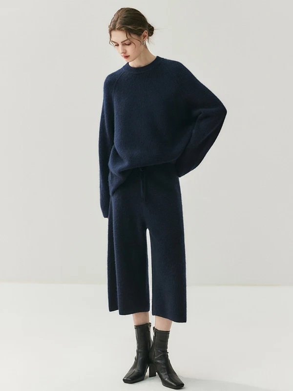 

Вязаный комплект из трех предметов: свитер с круглым вырезом, брюки с широкими штанинами и модная шапка для женщин