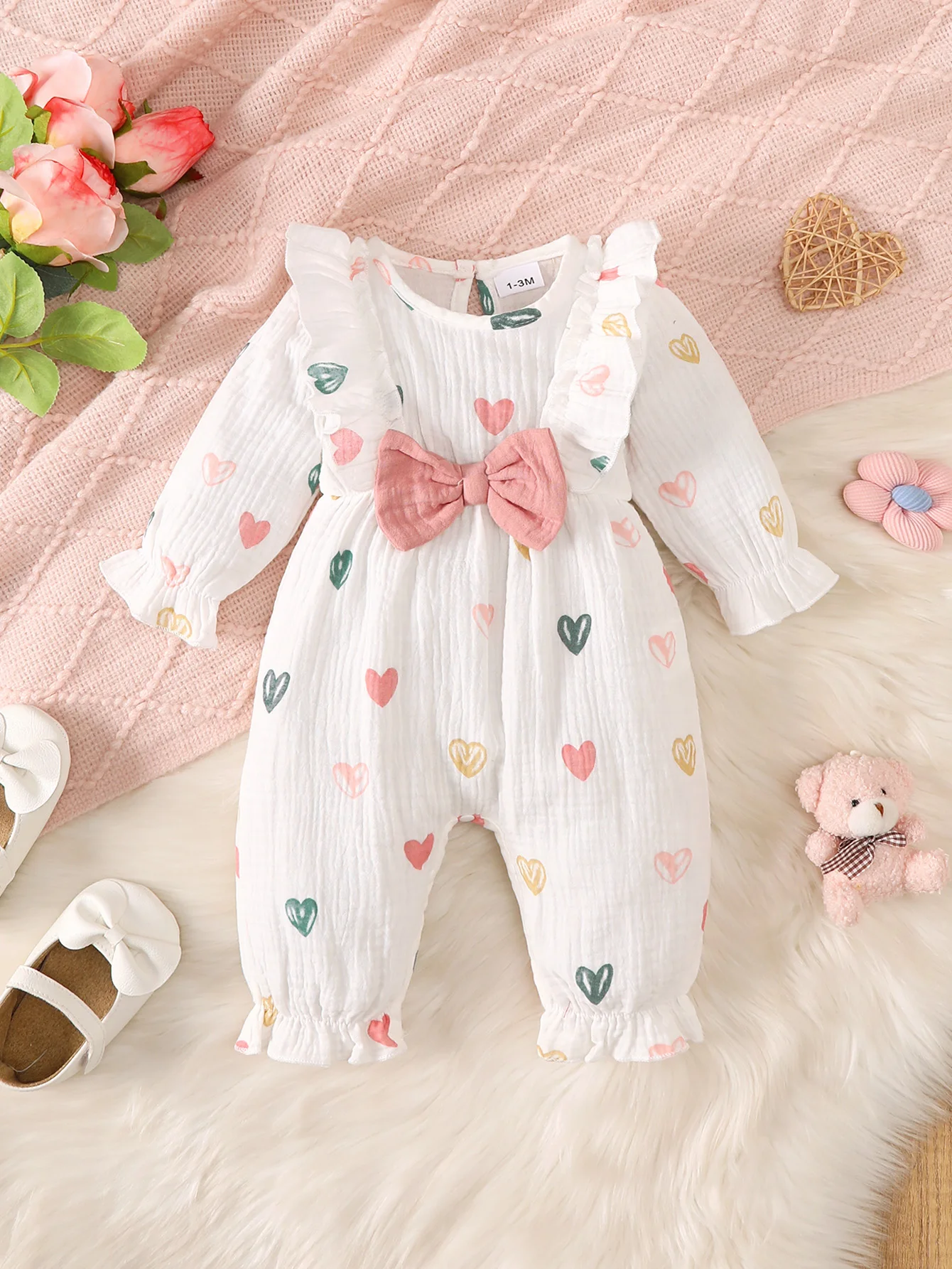 Frühlings- und Herbststil, süßer Baby-Mädchen-Overall mit langen Ärmeln, mit niedlichem Herz-Print-Muster, süßer Schleifendekoration auf der Brust, Outdoor-Strampler für Neugeborene, Baby-Mädchen-Overall. – Detail 1