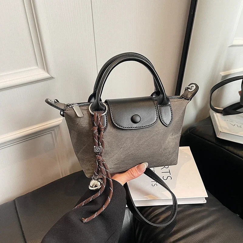 Elegancka torebka damska w stylu vintage, skórzana torba typu tote, klasyczna damska torba na ramię z mosiężnymi nóżkami i górnym uchwytem.