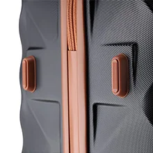 Close-up of gray luggage with rose gold accents, focusing on two secure locking mechanisms.