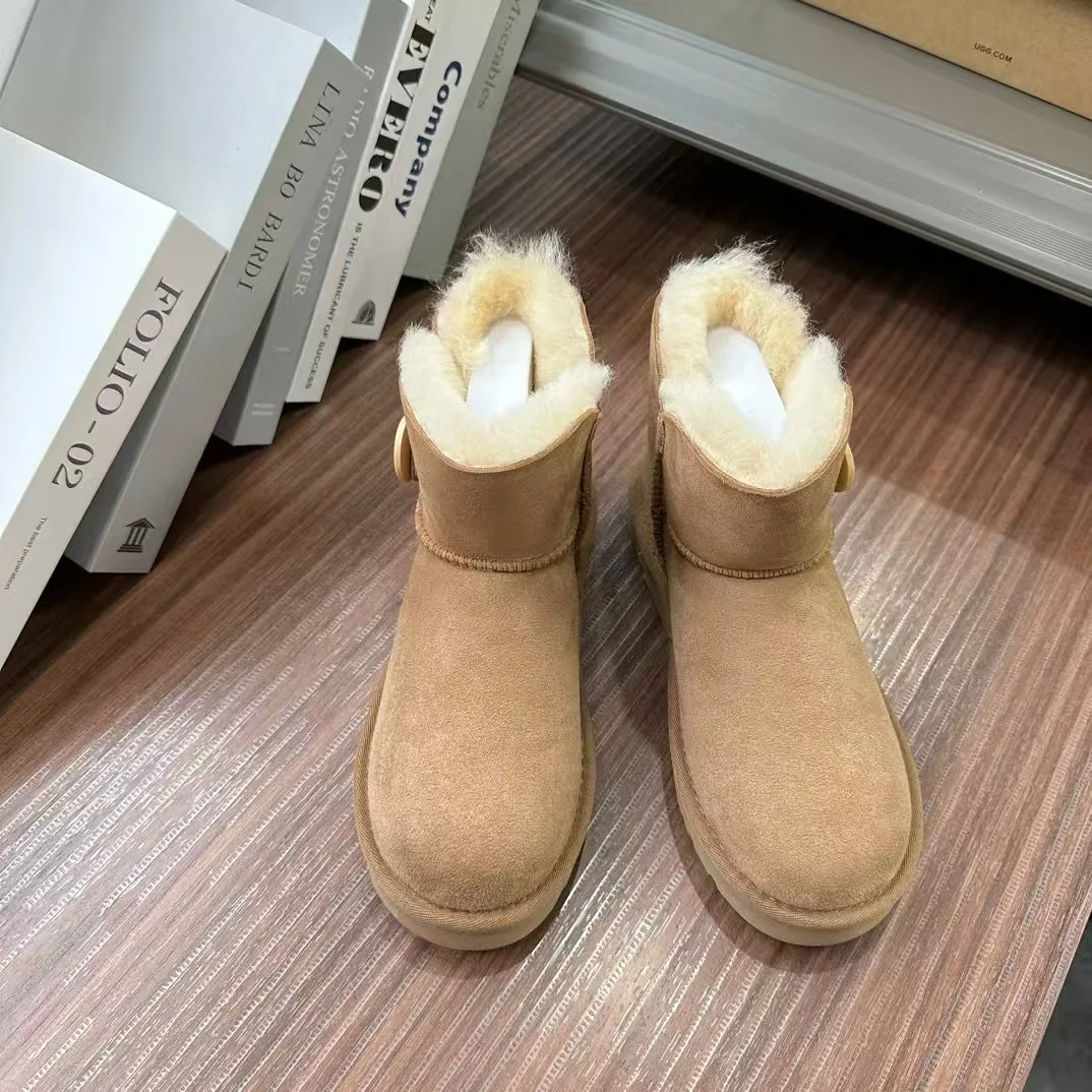 Nuevas botas de nieve de corte bajo de piel de oveja de invierno integradas para mujer impermeables estilo de botón de lana real cálido y cómodo fondo plano