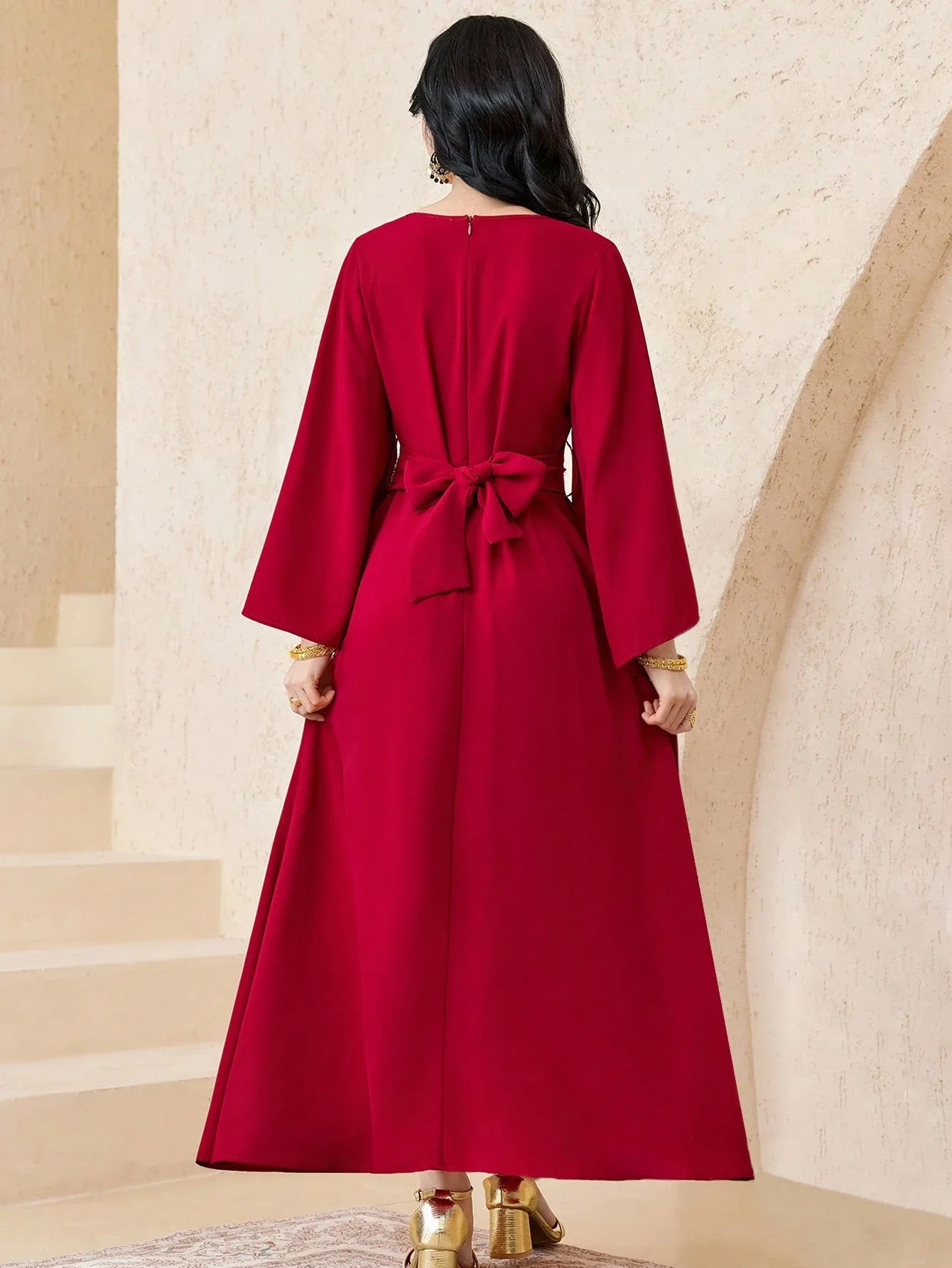 

Бордовое макси-платье с золотистым бахромчатым поясом, длинными рукавами, скромное вечернее платье