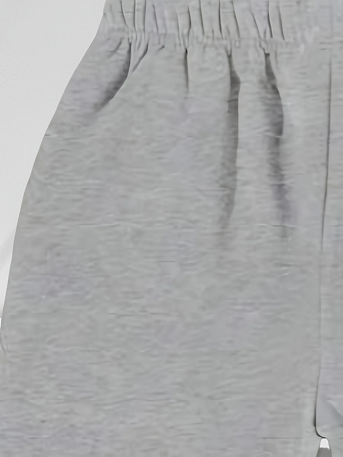 Calça de moletom casual masculina cinza folgada com punhos enrolados no tornozelo e cintura com cordão, adequada para todas as estações.