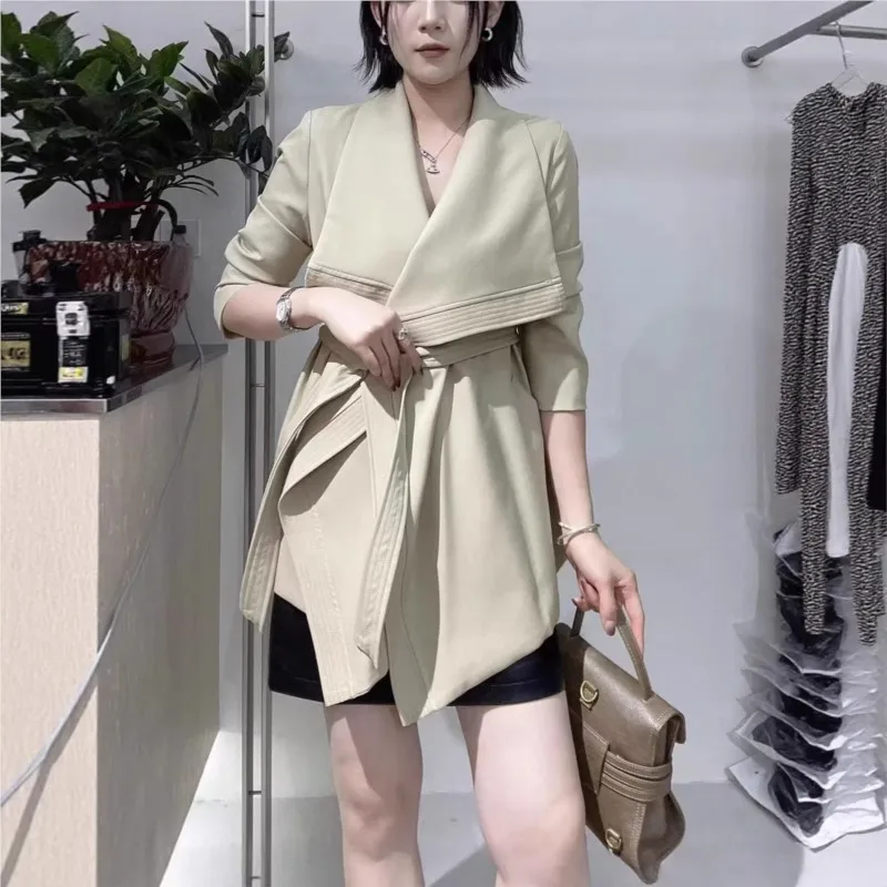 

A new khaki stylish short trench coat for women with loose lapel and tie