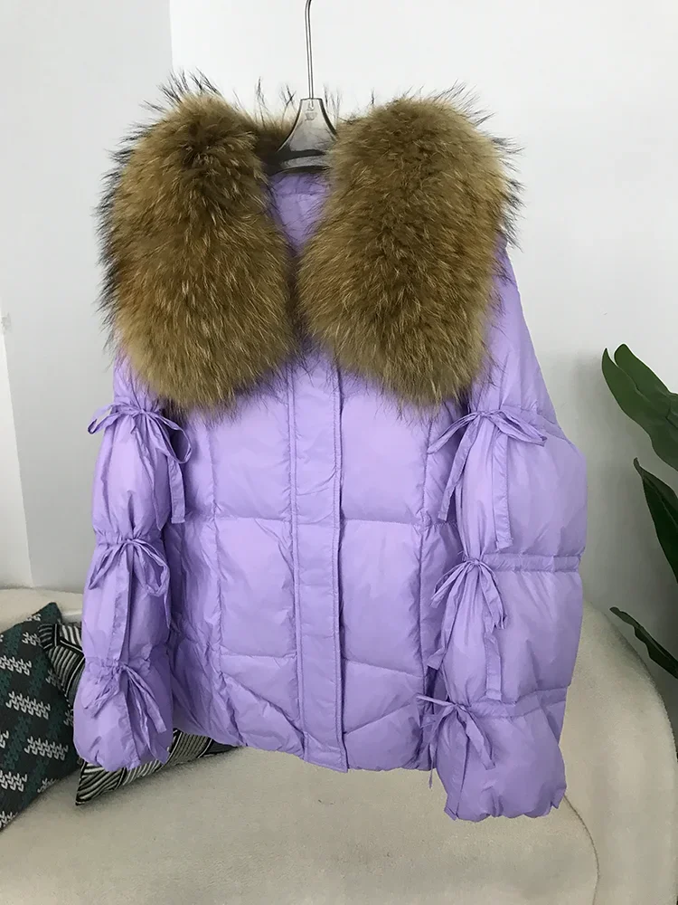 2025 الشتاء النساء بطة أسفل سترة معطف سوبر كبير ريال الراكون الفراء طوق مع ربطة القوس فيونكة كم موضة ملابس خارجية فاخرة