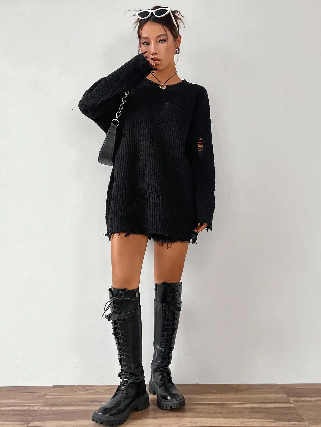 Damski sweter z dzianiny o luźnym kroju, z długim rękawem i obniżonymi ramionami, z efektem zniszczenia.