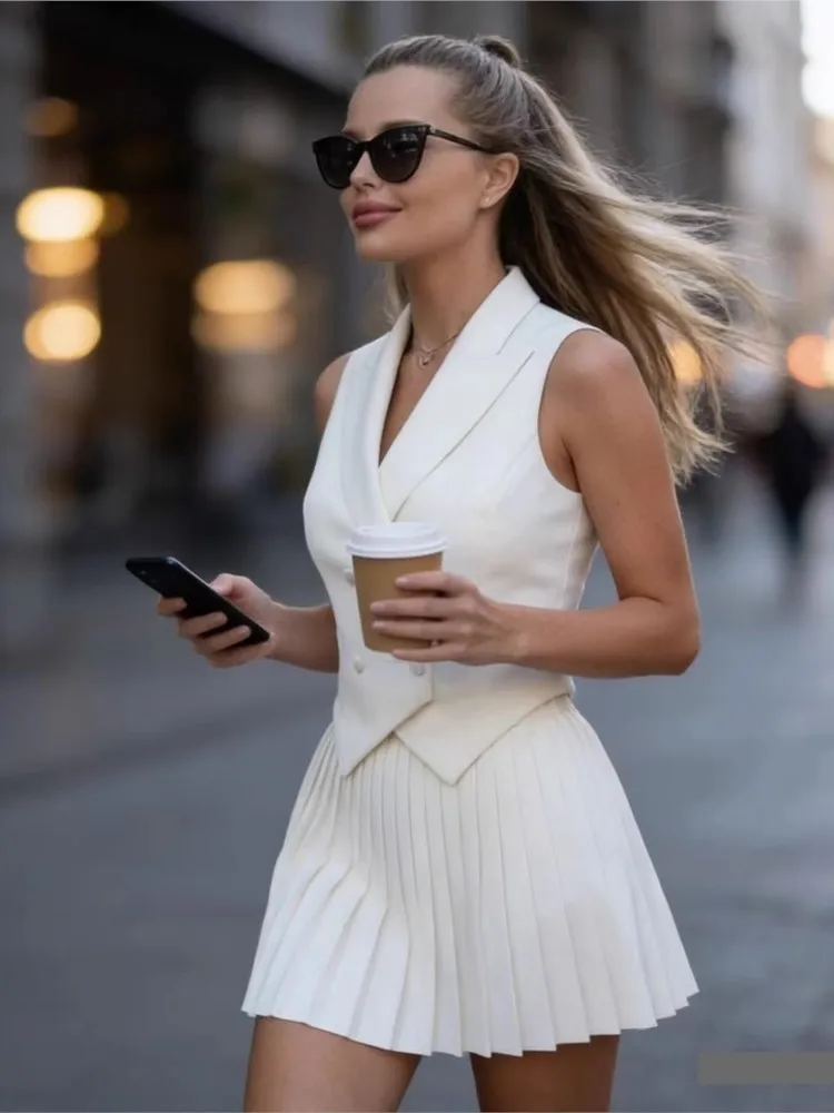 

Новый летний модный комплект: топ без рукавов с отложным воротником и асимметричным краем + плиссированная короткая юбка. Элегантный женский офисный костюм белого цвета.