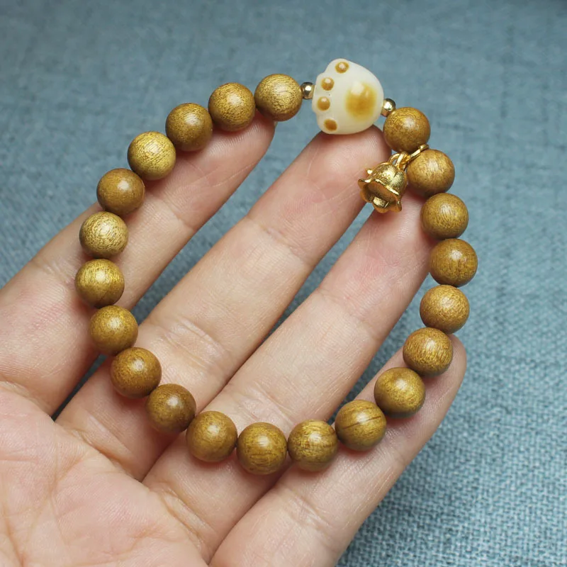 8mm old golden nanmu wood bracelet with carbon-burned cat paw and lily of the valley designs, unisex Buddhist beads in a forest
