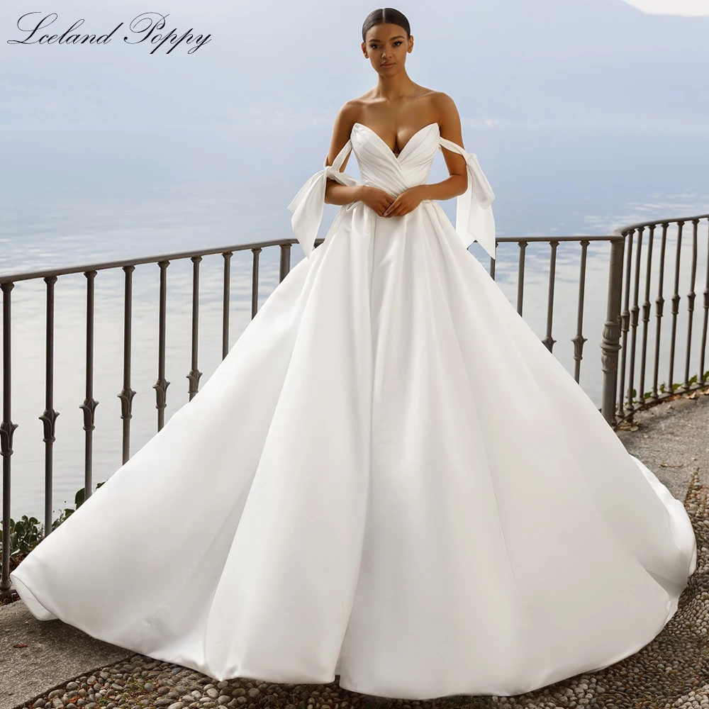 ชุดแต่งงานผ้าซาตินทรงเอไลน์แบบคอวี แขนตกไหล่ ประดับลูกปัด พร้อมชายกระโปรงยาวแบบชาเปล สไตล์ไอซ์แลนด์ป๊อปปี้  แบบสั่งตัดพิเศษ