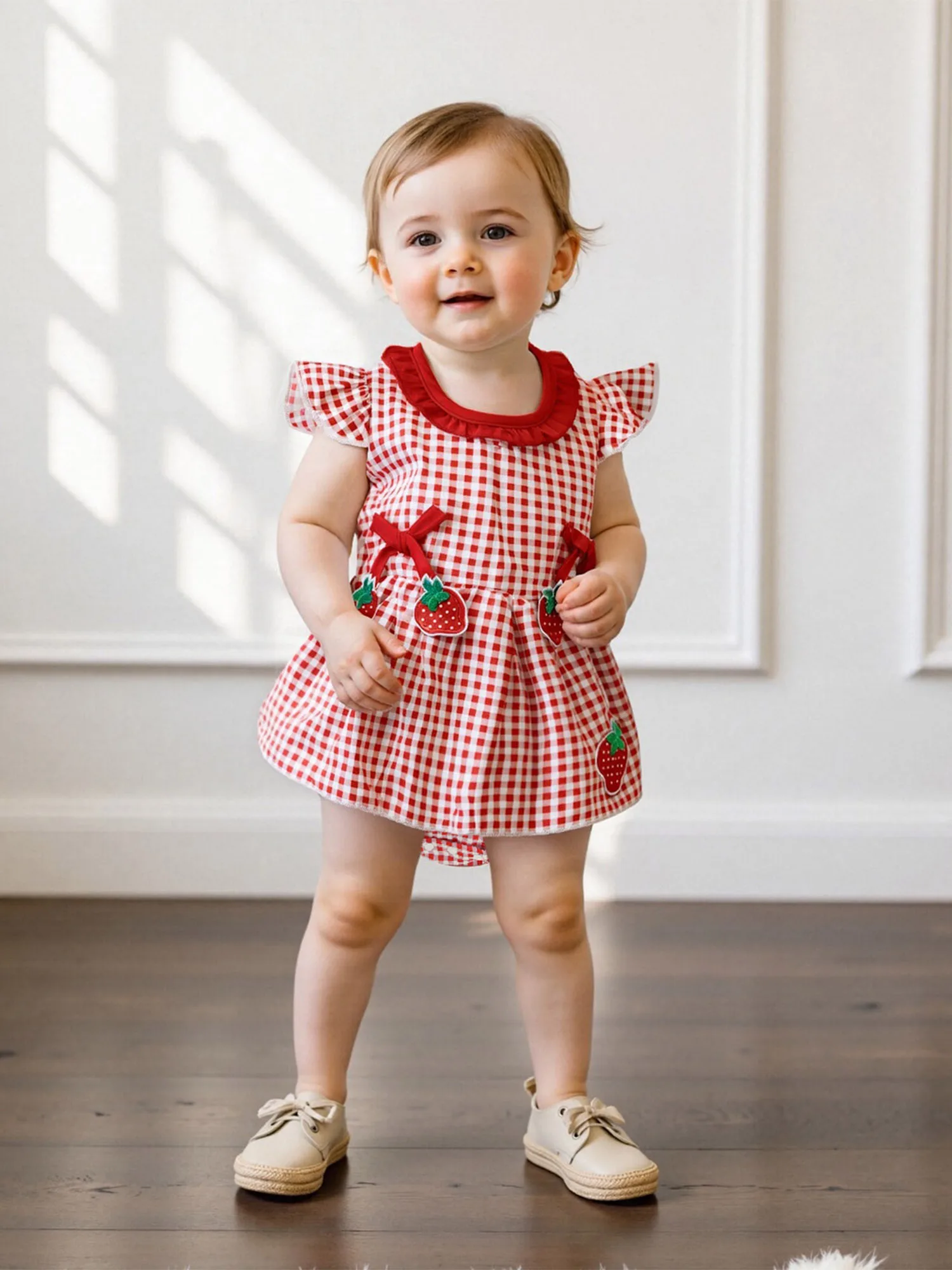 Abito da bambina con maniche a volant con stampa floreale e dettaglio fiocco per la festa di matrimonio estiva sulla spiaggia e il servizio fotografico di famiglia