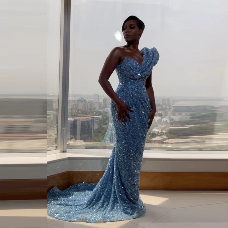ชุดราตรีผู้หญิงแอฟริกันสีฟ้าอ่อนประดับเลื่อมวิบวับ แบบไหล่เดียว ชายกระโปรงยาวลากพื้น สำหรับงานพรอมหรืองานเลี้ยง
