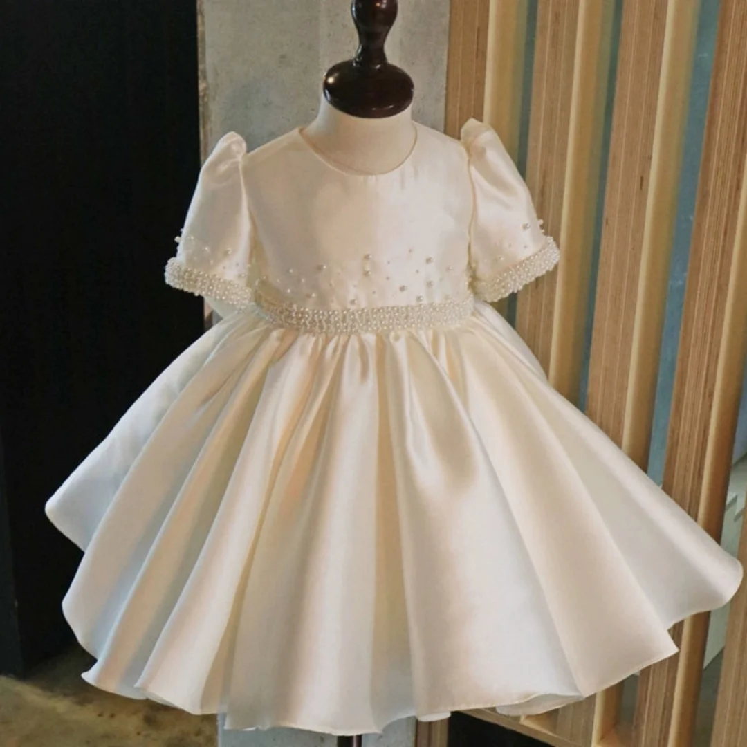 

White satin flower girl dress with 3D puff sleeves and pearl details Ideal for church events and violin performances.