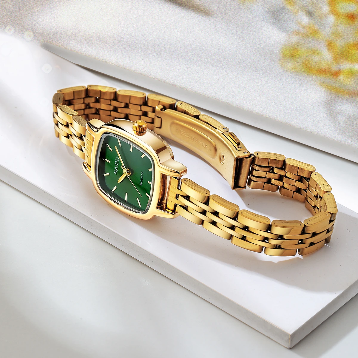 ساعة كوارتز بحزام من الفولاذ المقاوم للصدأ باللون الذهبي وبسيطة في مكان العمل