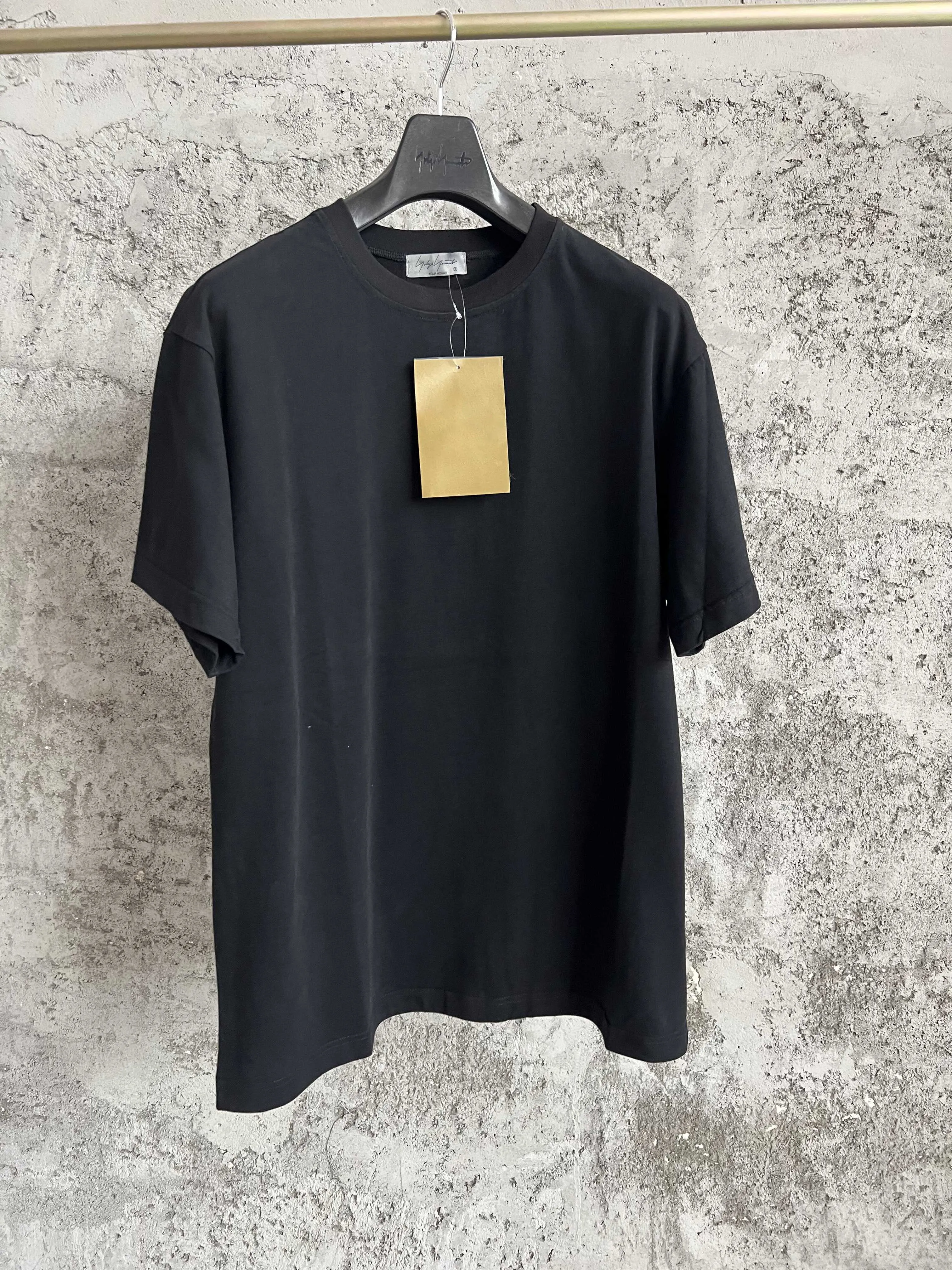 

This is a mid-length T-shirt with a stylish collar, a flowing ribbon on the front, and an asymmetrical hem