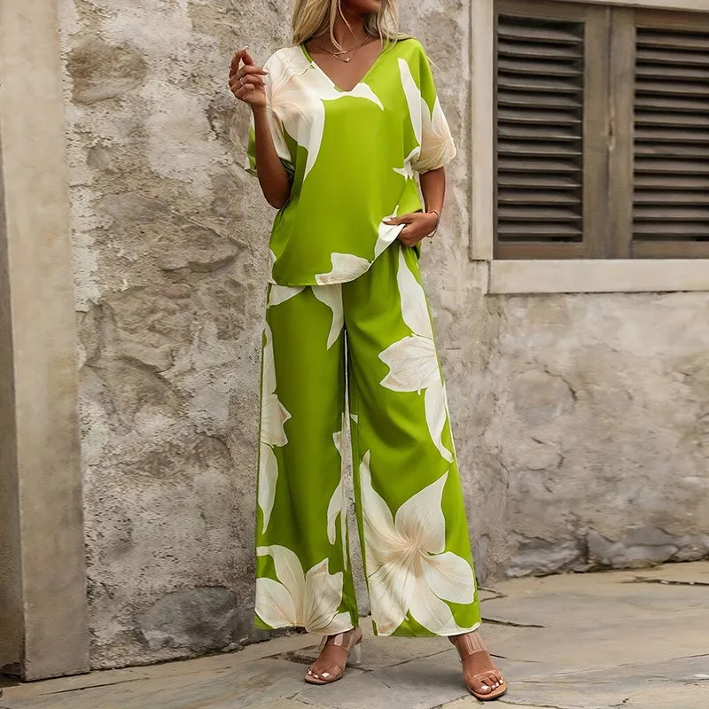 

Костюм-двойка женский: топ с V-образным вырезом, короткими рукавами-крылышками и цветочным принтом, а также широкие брюки в пляжном стиле для курортного отдыха