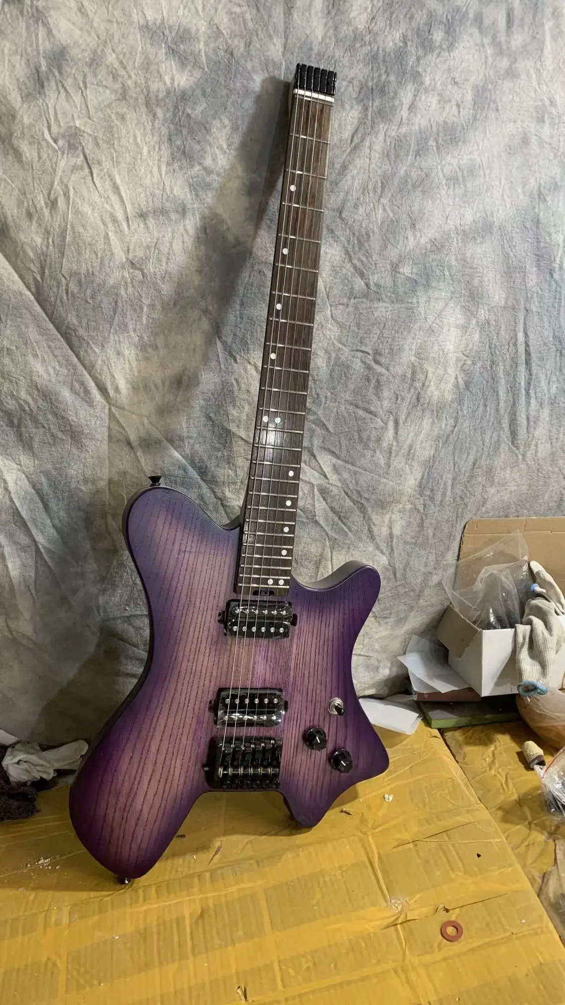 

Factory direct new 6 string headless electric guitar, ash wood body, five spelling neck, high-end headless bridge, support custo