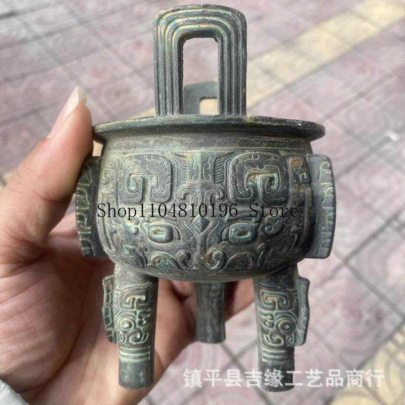 Round bronze-colored, antique-style, double-eared, three-legged, relief-decorated incense burner, a handcrafted alloy piece rese