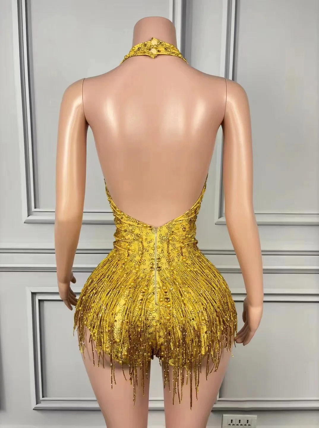 Seksowny kombinezon bez pleców z głębokim dekoltem w kształcie litery V, zdobiony cyrkoniami, idealny na zawody tańca latynoamerykańskiego w stylu standardowym.
