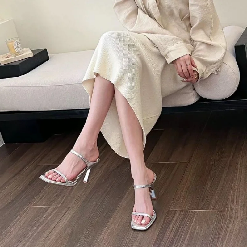 شباشب فضية مسائية على الطراز الخيالي، شباشب بكعب عالٍ بحزام واحد، شباشب صيفية خارجية لعام 2025 للفساتين