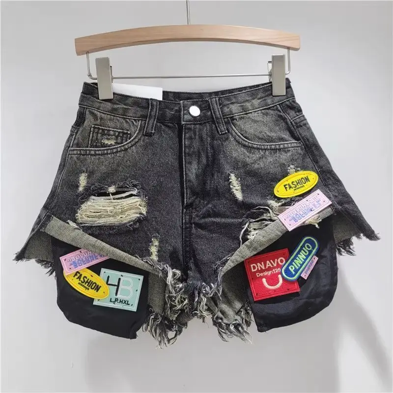 新しいトレンドのレディース スプライスドホール バーリーエッジ デニムショートパンツ 2026 夏 ファッション ハイウエスト Aライン ショートパンツ 女性用