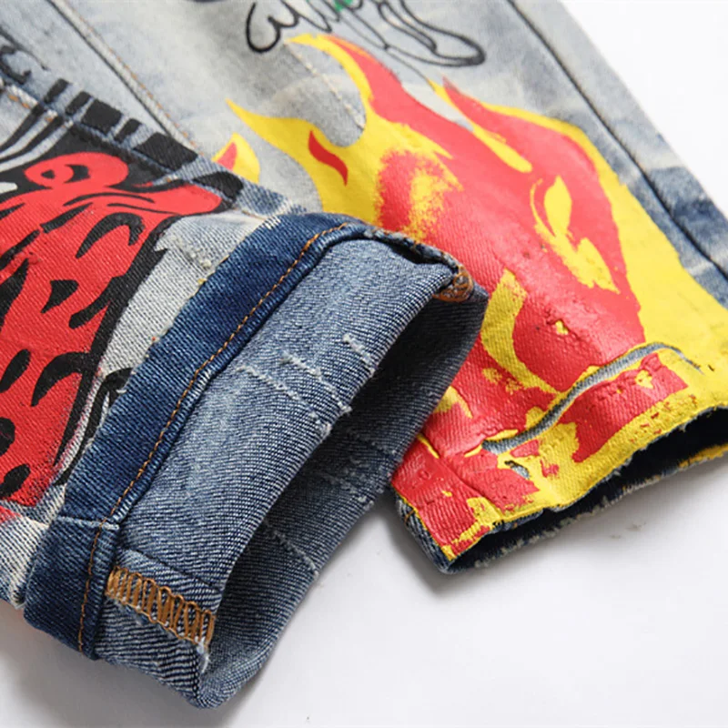 Jeans in Denim elasticizzato da uomo con stampa Streetwear personaggio teschio dipinto a fiamma pantaloni Vintage bottoni pantaloni sottili strappati