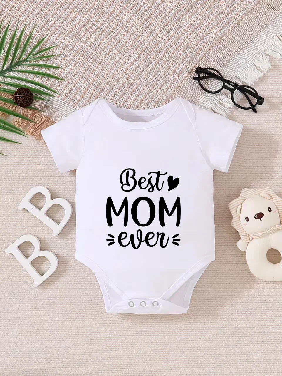 Playful letter-printed baby short-sleeve triangle bodysuit. Button closure for easy dressing, machine washable