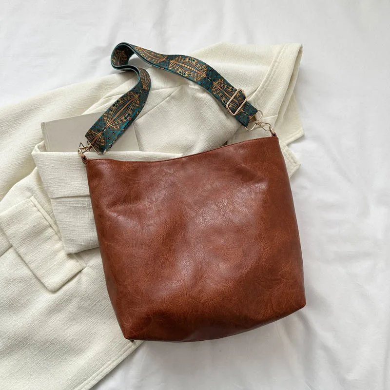 

2025 A/W trendy bag with a wide strap. Soft leather, spacious & retro-chic for a stylish, comfortable carry.