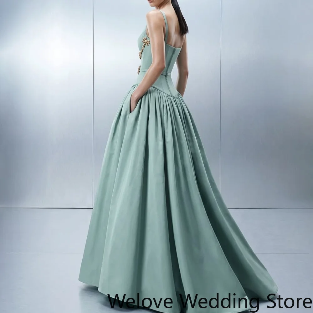 Elegant Mint Green Formal Ball Gown Featuring a Square Neckline, Thin Straps, and Intricate Gold Embellishments at the Waist