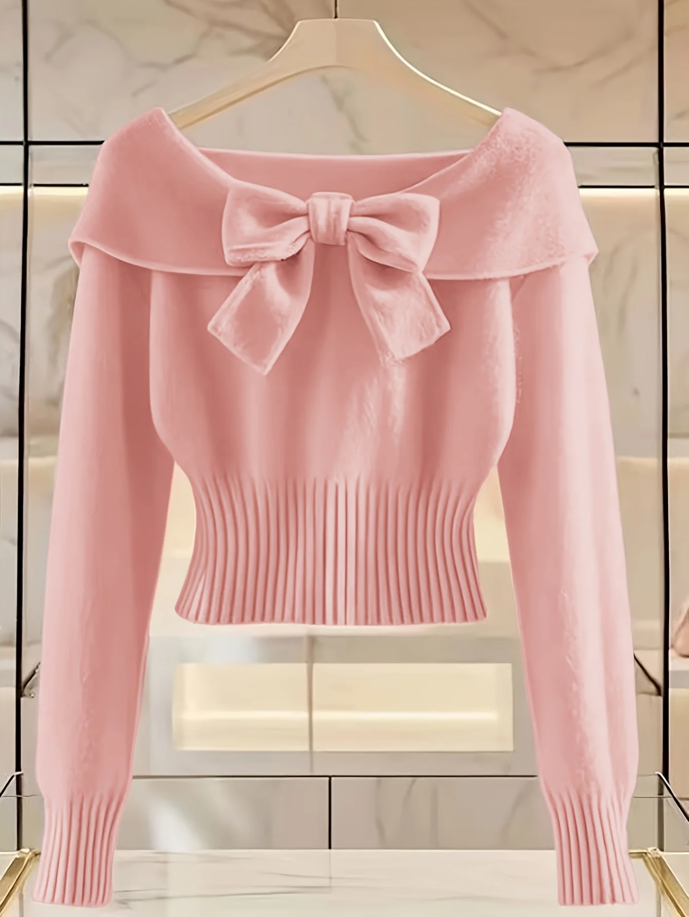

Lady's elegant pink bow tie sweater, long sleeves and round neckline, ribbed texture, suitable for autumn and winter seasons.