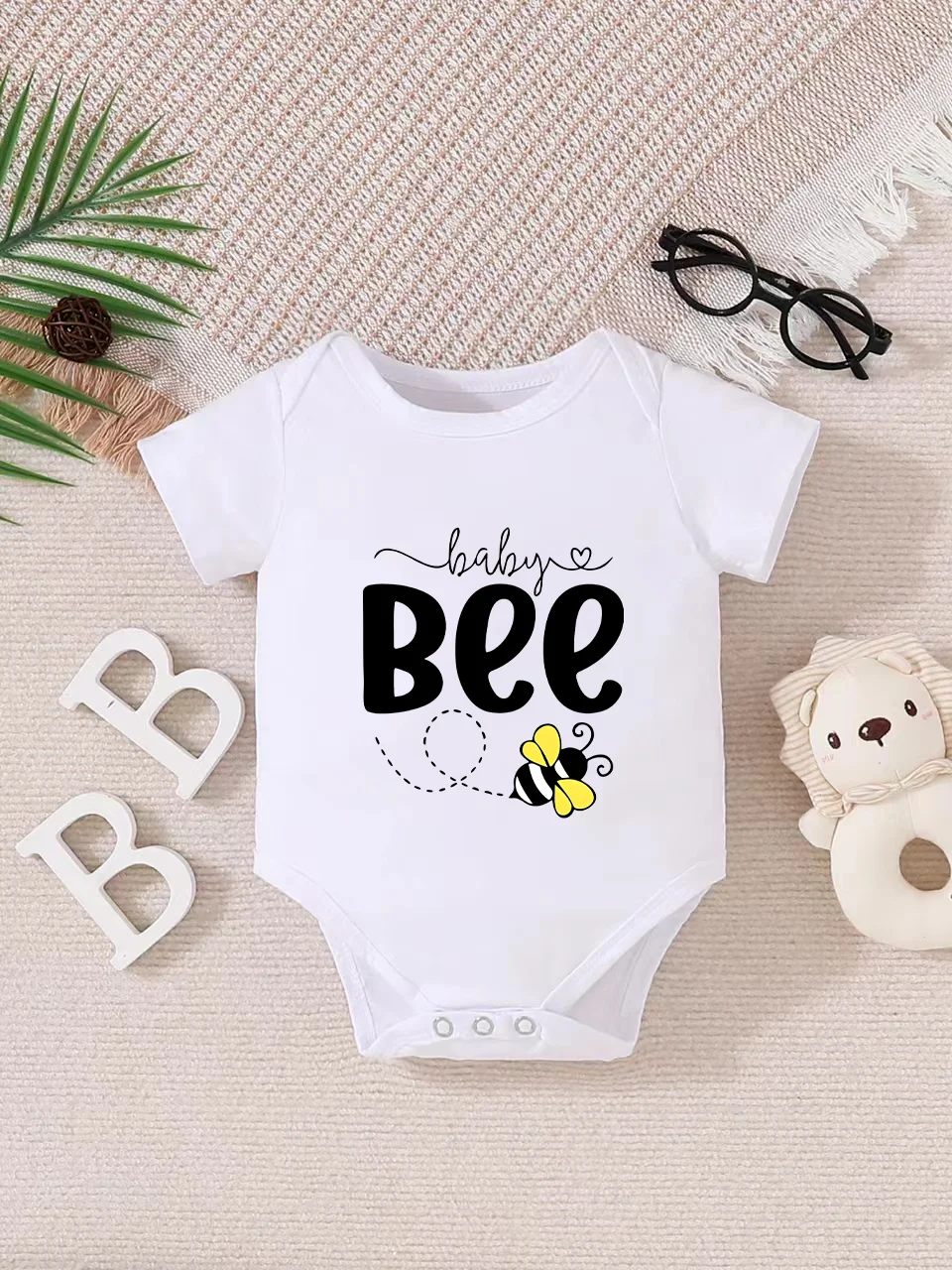 Playful letter-printed baby short-sleeve triangle bodysuit. Button closure for easy dressing, machine washable