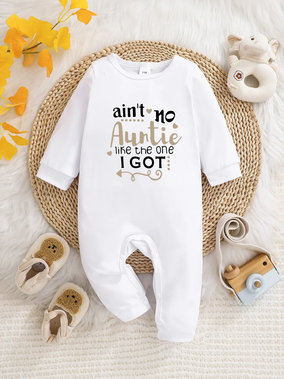 Ein langärmeliger Baby-Strampler mit interessanten Buchstaben-Prints. Es verfügt über ein Knopfverschluss-Design für einfaches An- und Ausziehen, und