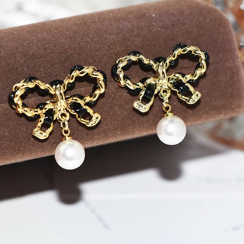 

Black and gold contrasting color bow pearl high-end light luxury stud earrings